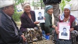 Kyrgyz mothers hold photos of missing relatives