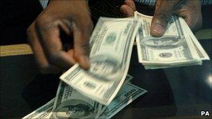 man counting out US dollars