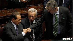 Silvio Berlusconi (left) is congratulated by allies Umberto Bossi (right) and Giulio Tremonti (centre)