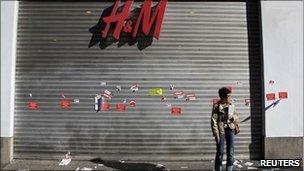 A woman stands in front of a closed shop in Madrid, Spain, on 29 September, 2010.