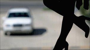 Silhouette of prostitute's legs with a car approaching