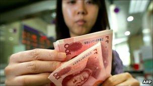 bank teller counting Chinese currency 100 yuan notes in Beijing