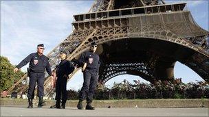 French police officers patrol under the Eiffel Tower in Paris