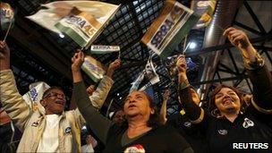 Supporters of Jose Serra wave flags after hearing that he goes to the second round, 3 October 2010