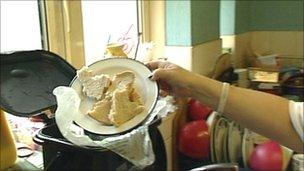 Woman putting scraps of bread into one of the recycling bins