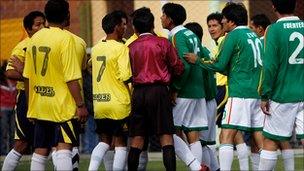 President Morales in a group of players arguing with the referee