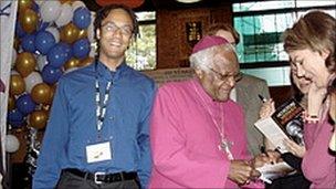 Deji Olukotun smiling behind Archbishop Tutu