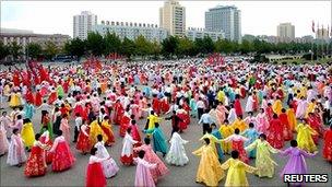 North Koreans dance during an event celebrating the 65th anniversary of the Workers' Party