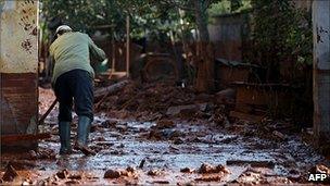 A Hungarian man cleans up after sludge spill in Devecser