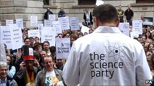 Protesters including scientists gather outside the Treasury in London to protest Government cuts to science (PA)