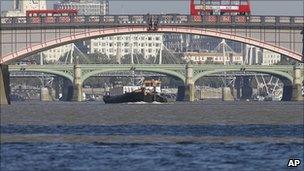 A tug boat plies its trade along the River Thames, with Lambeth Bridge in foreground, and Westminster Bridge