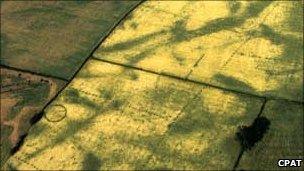 A ringed ditch (left), the site of a burial mound, at Four Crosses