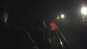 Passengers walk through Tube tunnel