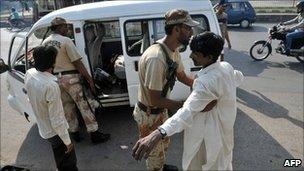 A Pakistani paramilitary soldier frisks a man in Karachi