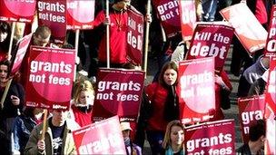 Students holding signs reading grants not fees