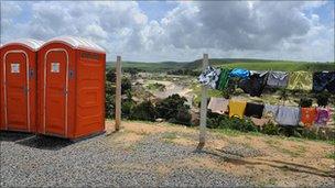 Temporary toilets and a washing line at the tent camp