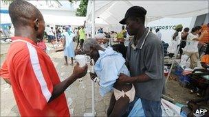 A man with fever is helped at a hospital in Saint-Marc, Haiti - 21 October 2010