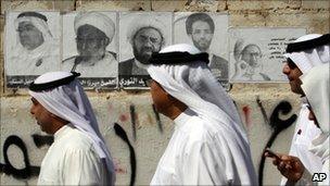 Bahraini men walk past election posters in the village of Diraz (22 October 2010)