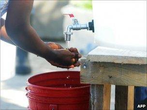 Health worker washing her hands outside St Nicholas hospital, St Marc, Haiti (24 Oct 2010)