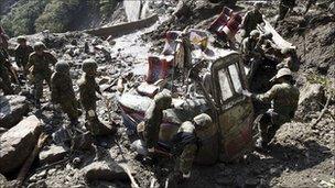 Mangled vehicle parts thought to be a missing bus carrying 19 Chinese tourists