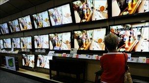 Customer looking at flat screen televisions on display in a store in California