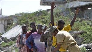 A Somali government soldier frisks a resident in the streets in southern Mogadishu