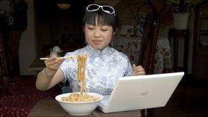 Young Chinese woman using a lap top in a restaurant