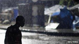 A man walks in the rain in the Haitian capital, Port-au-Prince, on 31 October