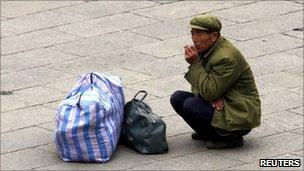 A migrant worker waits for a train in Beijing on 19 October 2010