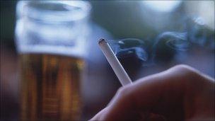 Man smoking cigarette and drinking pint of beer