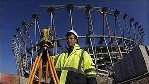 A worker takes measures at the construction site of the National Stadium in Warsaw