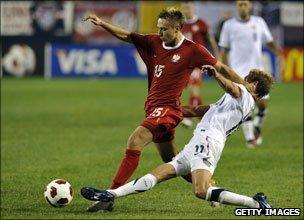 Adam Matuszczyk of Poland holds off Stuart Holden of the US during October's game in Chicago