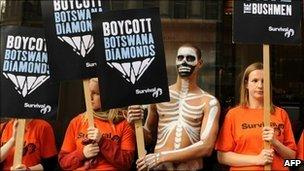 Demonstrators hold placards as they protest outside De Beers in central London