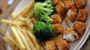 Dinner plate of nuggets and chips and broccoli