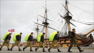 The Royal Navy team walking past HMS Victory