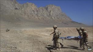 Canadian troops rescue an injured Afghan civilian