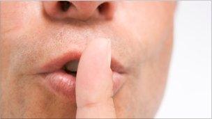 Man with finger on lips