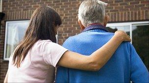 Care worker helping a man into his home