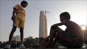 Indian boys chat in the backdrop of the Adarsh Housing Society apartments in Mumbai on 1 November 2010