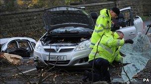 Investigators examine the scene where a woman died after a tree hit her car during stormy weather in West Yorkshire on Thursday 11 November