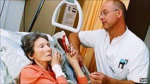 A nurse helping a terminally ill patient put on some make-up