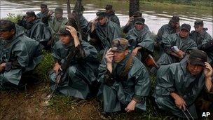 Nicaraguan troops kneel as a helicopter takes off beside the San Juan river