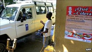 Dominican health worker disinfecting a UN vehicle as it crosses the border from Haiti, 27 October 2010