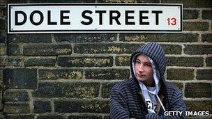 Jobseeker standing below sign for Dole Street in Bradford