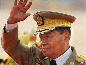 General Than Shwe waves as he reviews troops during a military parade (March 2010)