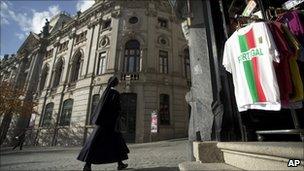 A nun passes by a Bank of Portugal branch in Porto (17 Nov 2010)