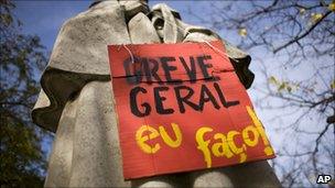 Placard reading: "General Strike I do it!" on a statue in the centre of Lisbon