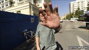 A security guard tries to stop photographs being taken outside the house of the wife of jailed Chinese Nobel Peace laureate Liu Xiaobo on 15 October 2010