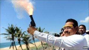 Sri Lanka's president Mahinda Rajapakse fires a gun during the inauguration of the Chinese-funded port in Hambantota on November 18, 2010.