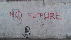 Banksy painting of a child sitting under the words 'no future'